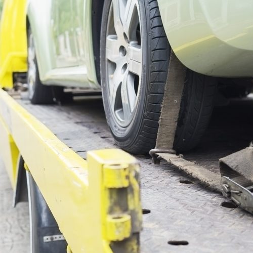 car transporter breakdown lorry during working using locked belt transport other green car for repairing at car center in a bangkok city thailand